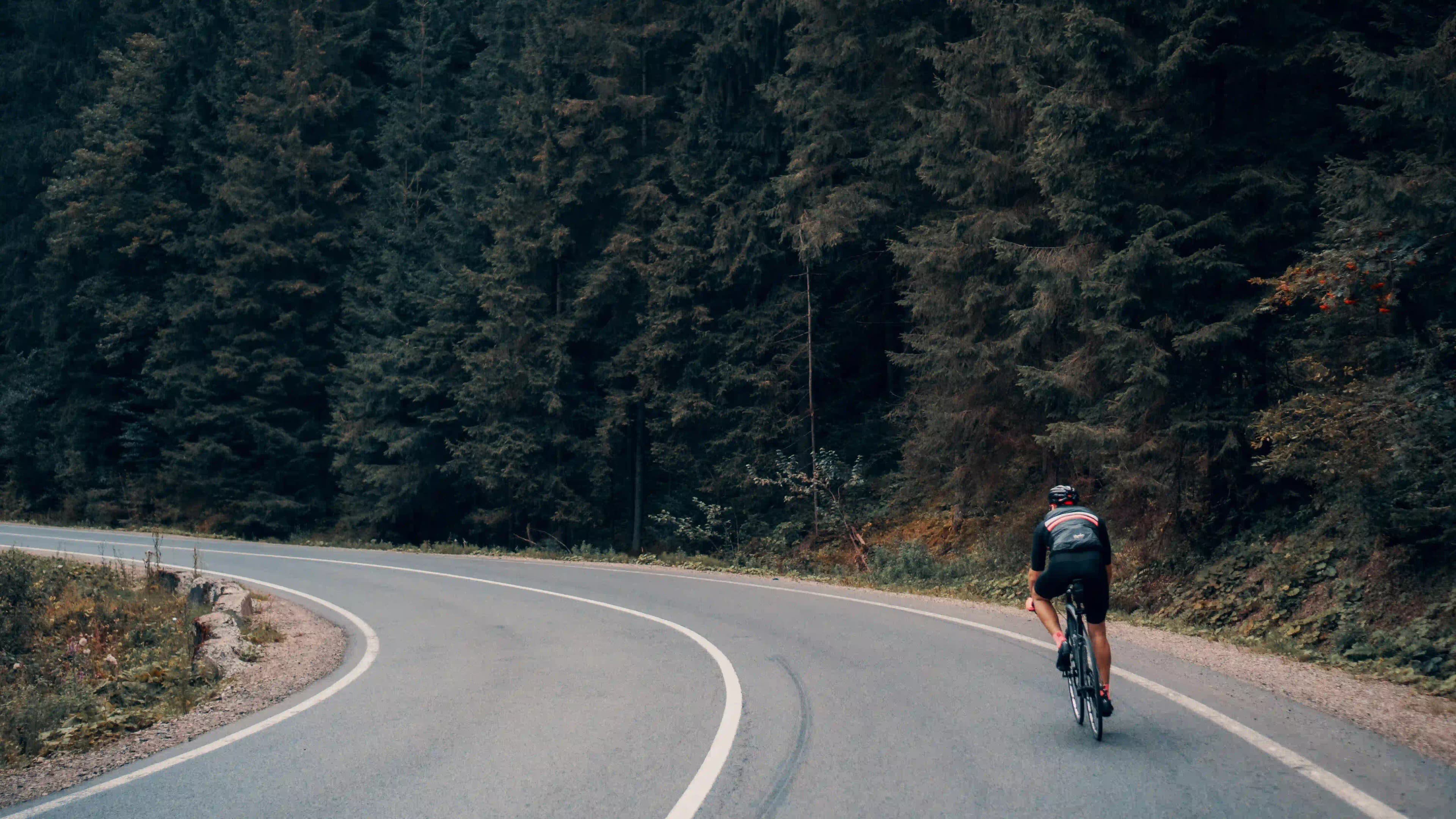 Man cycling on bending road